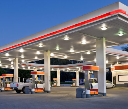 Horizontal shot of a retail gasoline station and convenience store at dusk.